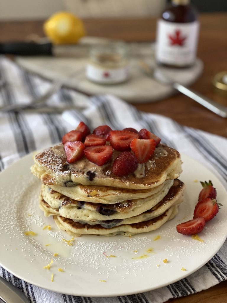 Lemon and blueberry pancakes with maple butter and strawberries