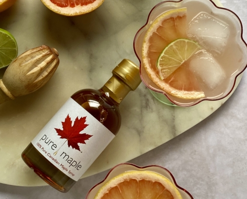 Maple paloma cocktails with grapefruit lime and maple syrup bottle